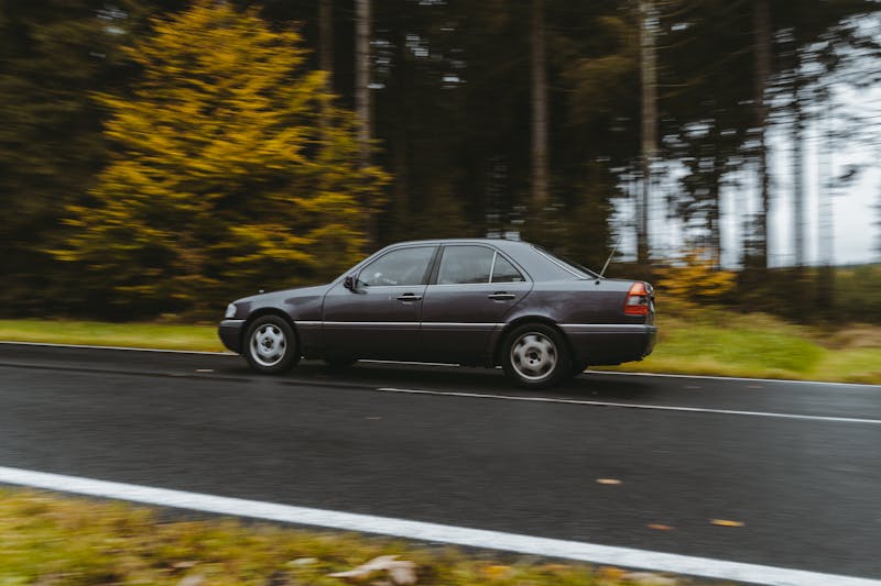 Voiture sur route mouillée en automne